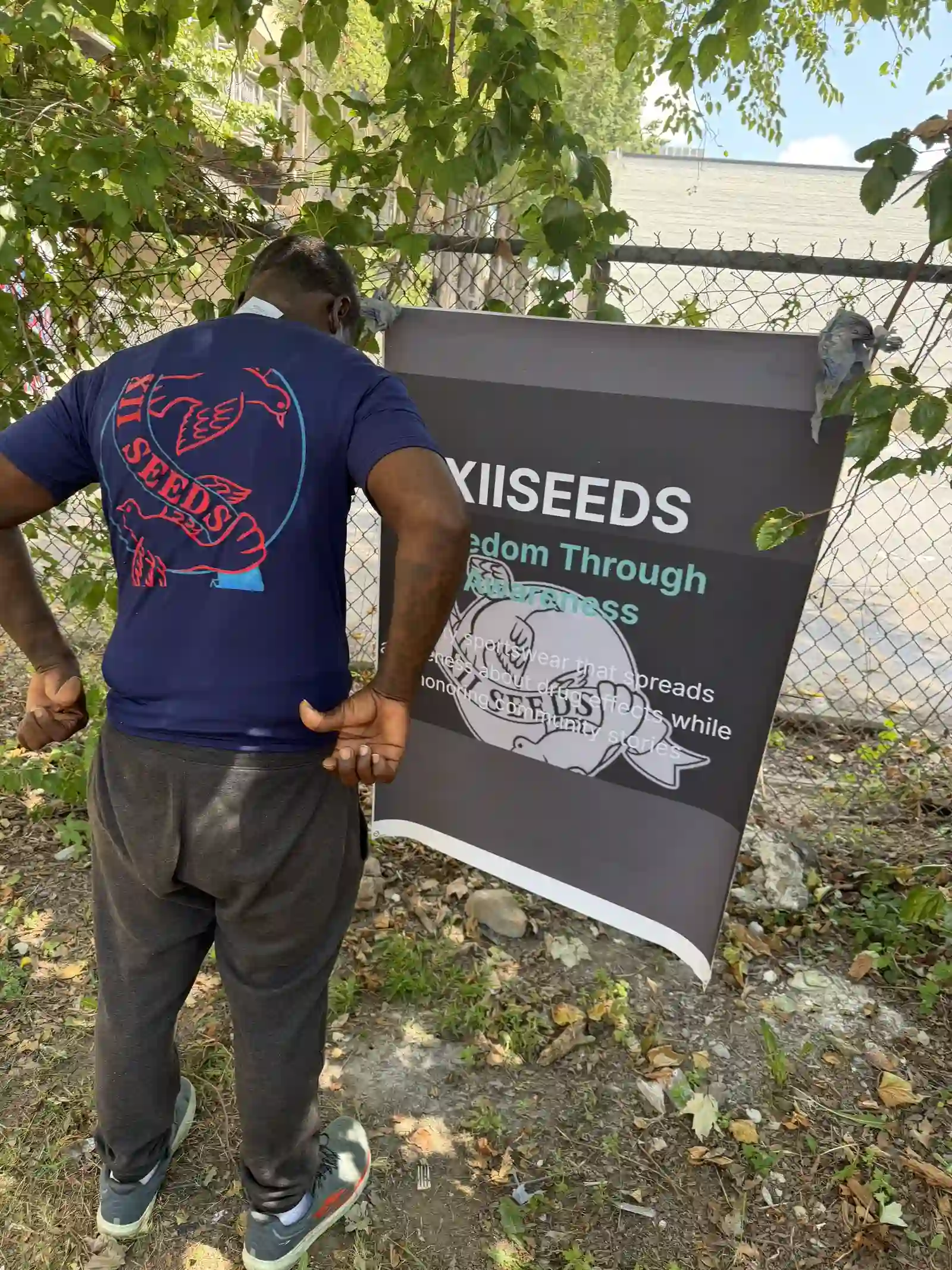 Back of a purple XIISEEDS tee showing the logo design