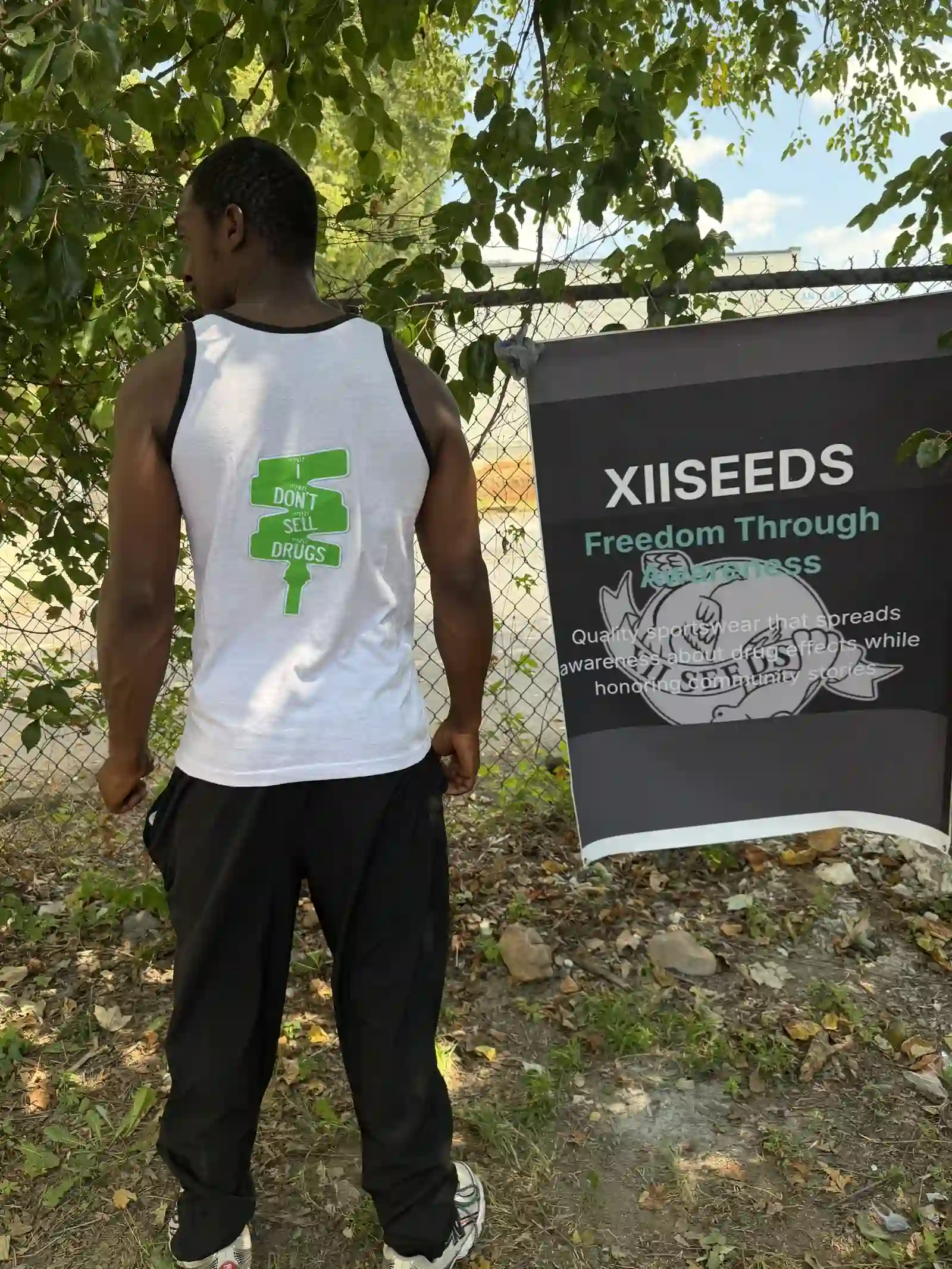 Back of a white XIISEEDS tank top with the seed logo