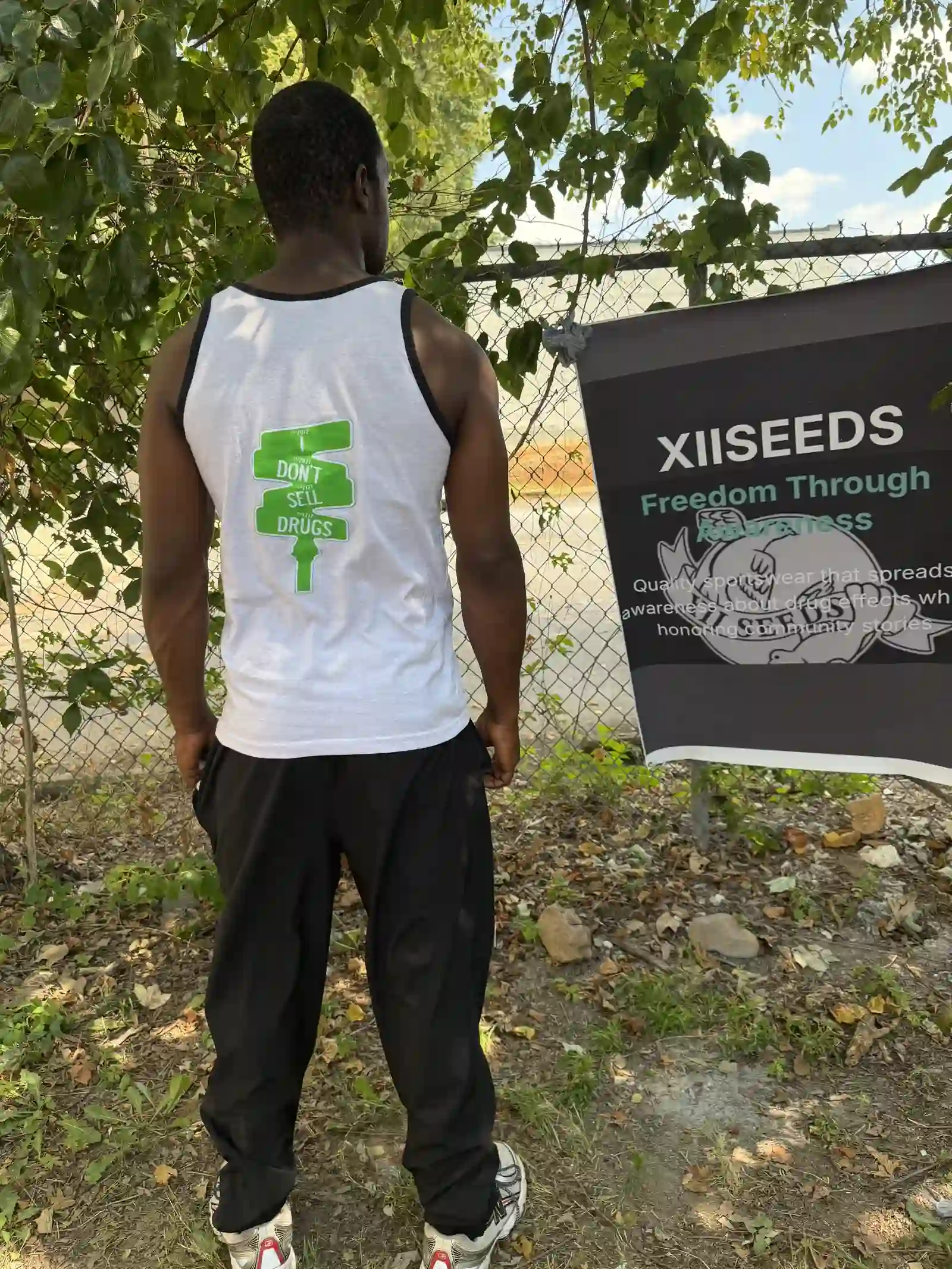 Volunteer wearing a white XIISEEDS tank top, back view