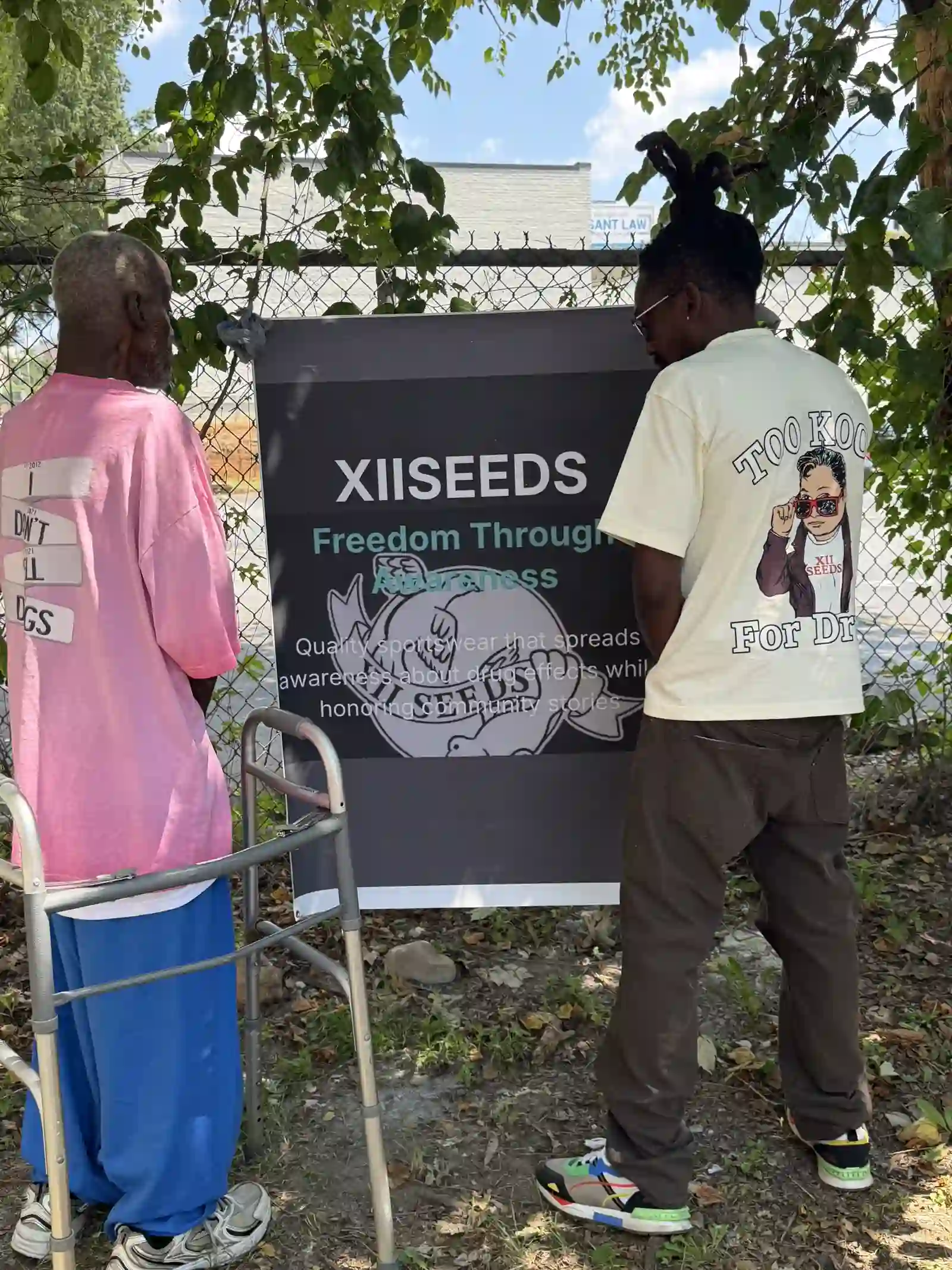 Two men standing together near the XIISEEDS banner