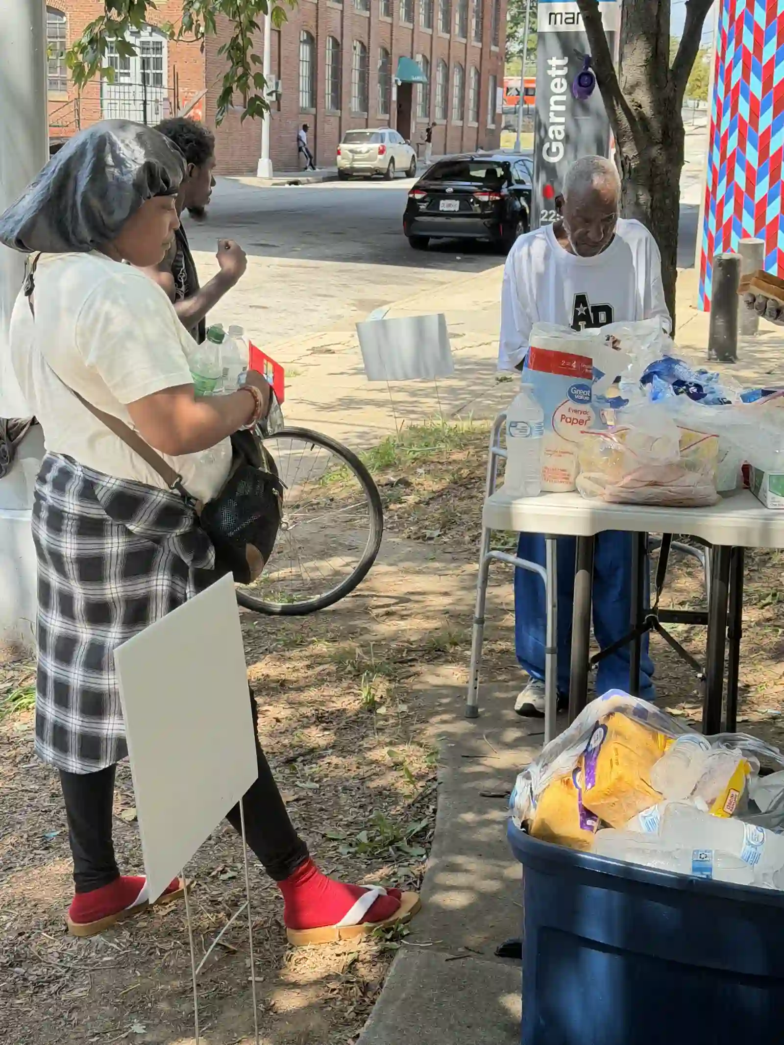 Volunteers set up at the outreach supply table on the sidewalk