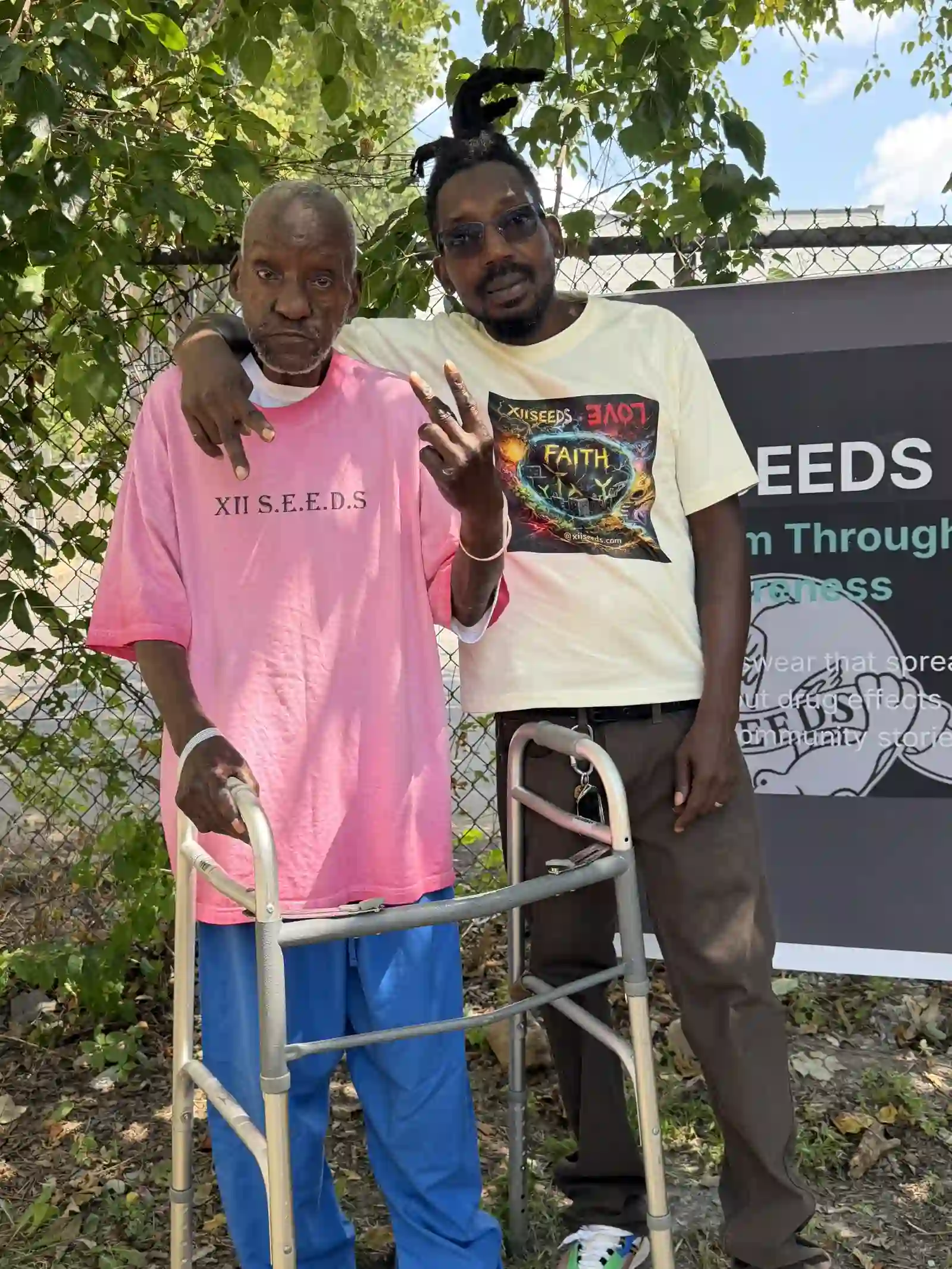 Two men posing together near the mission banner