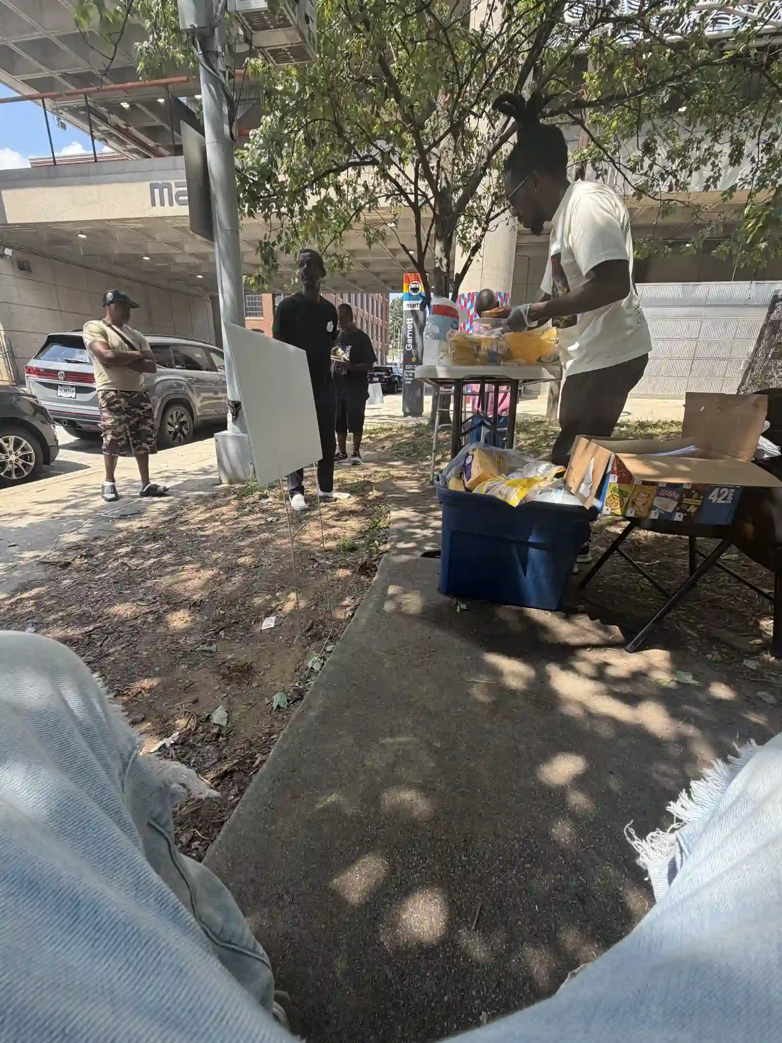 Community members gathered around the outreach supply table