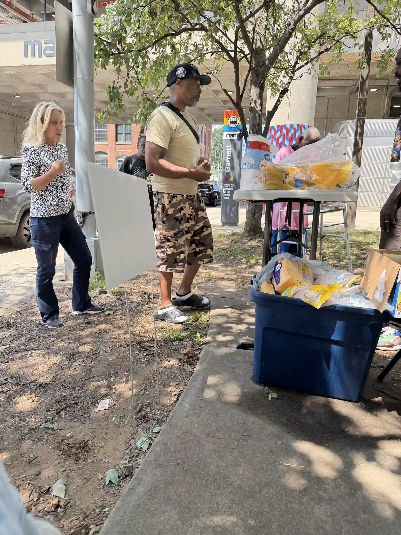 Volunteer greeting a community member near the supply table