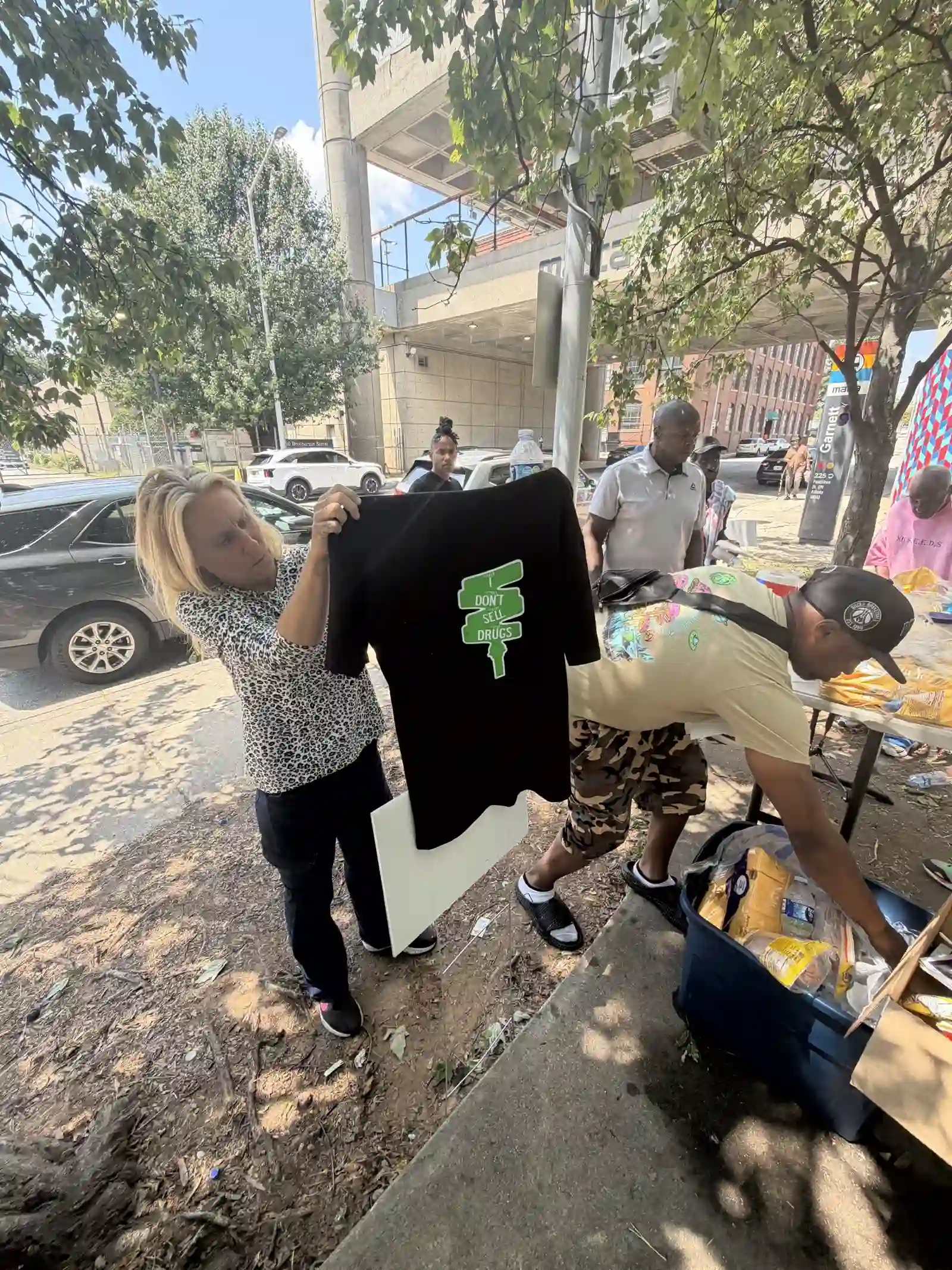 Volunteer holding up a shirt at the outreach table