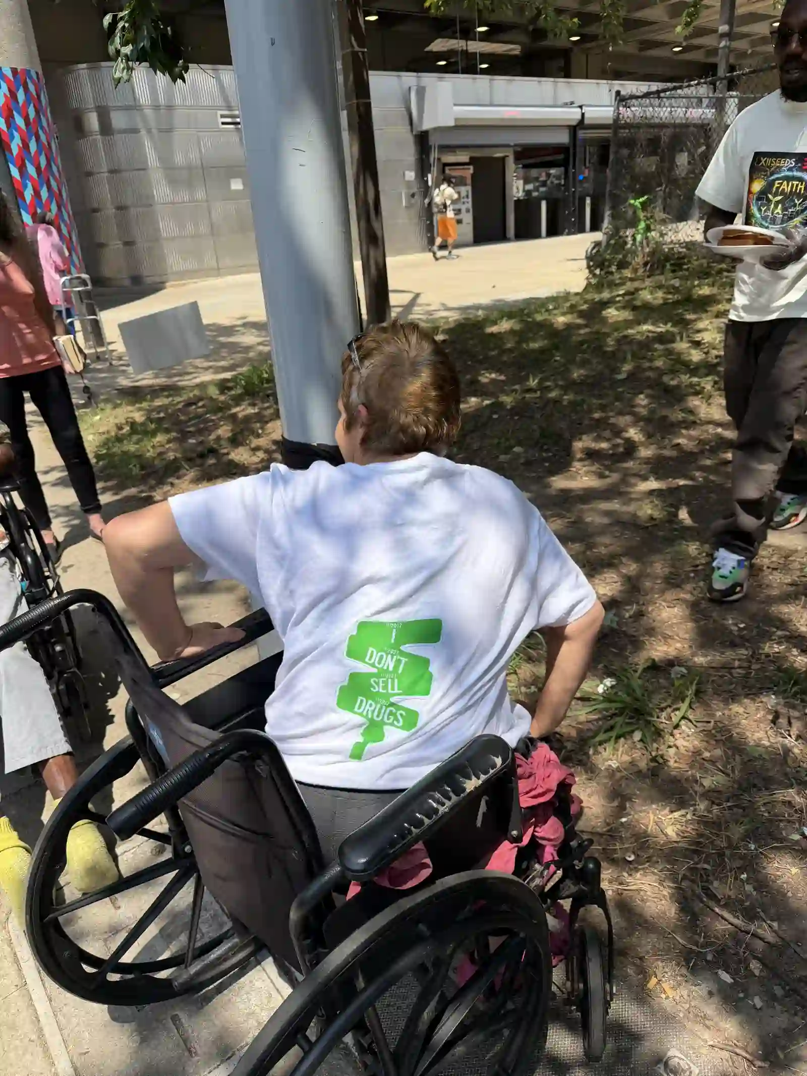 Man in a wheelchair, back view, wearing an XIISEEDS shirt