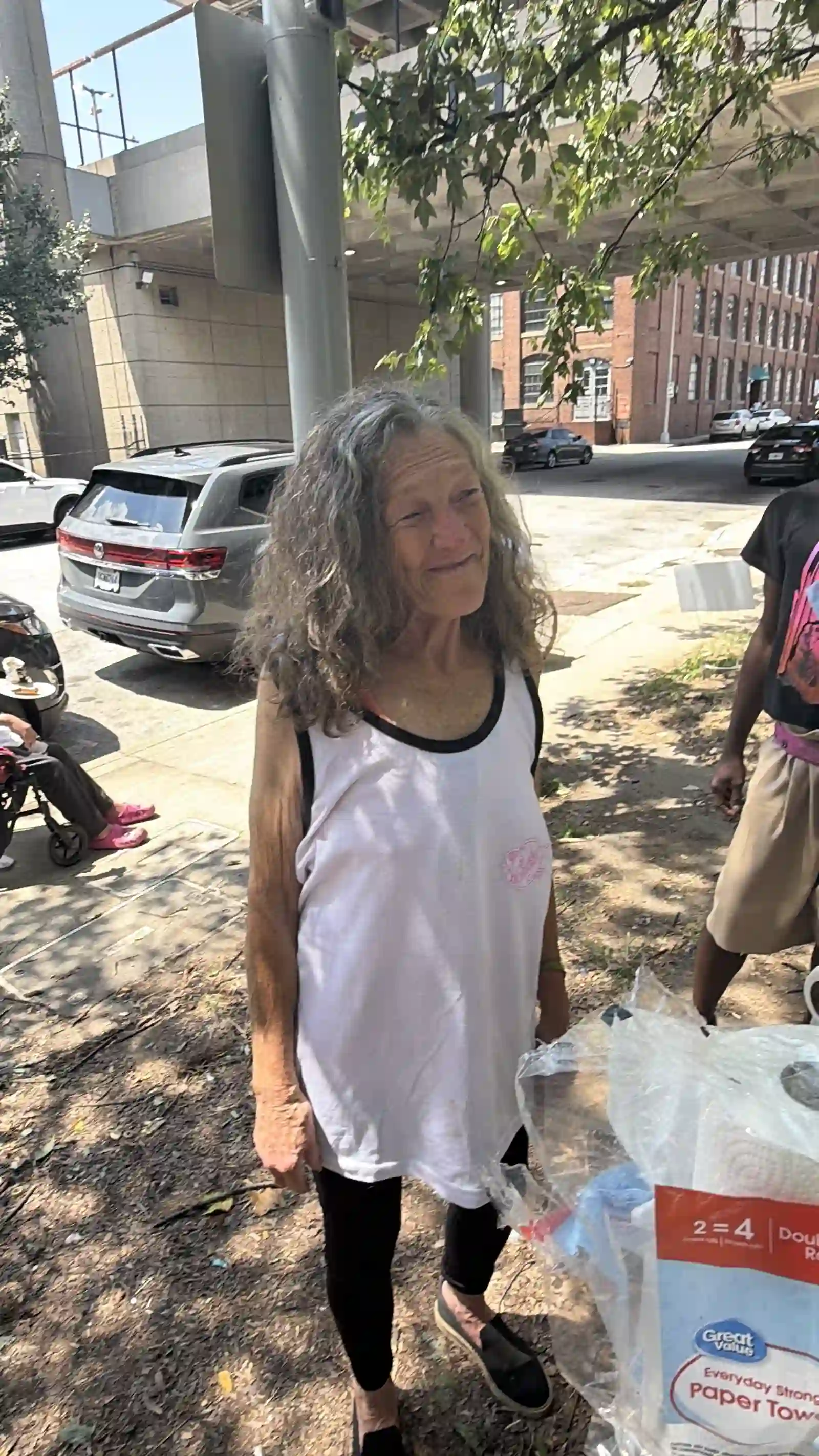 Woman standing with bags of supplies from the outreach event
