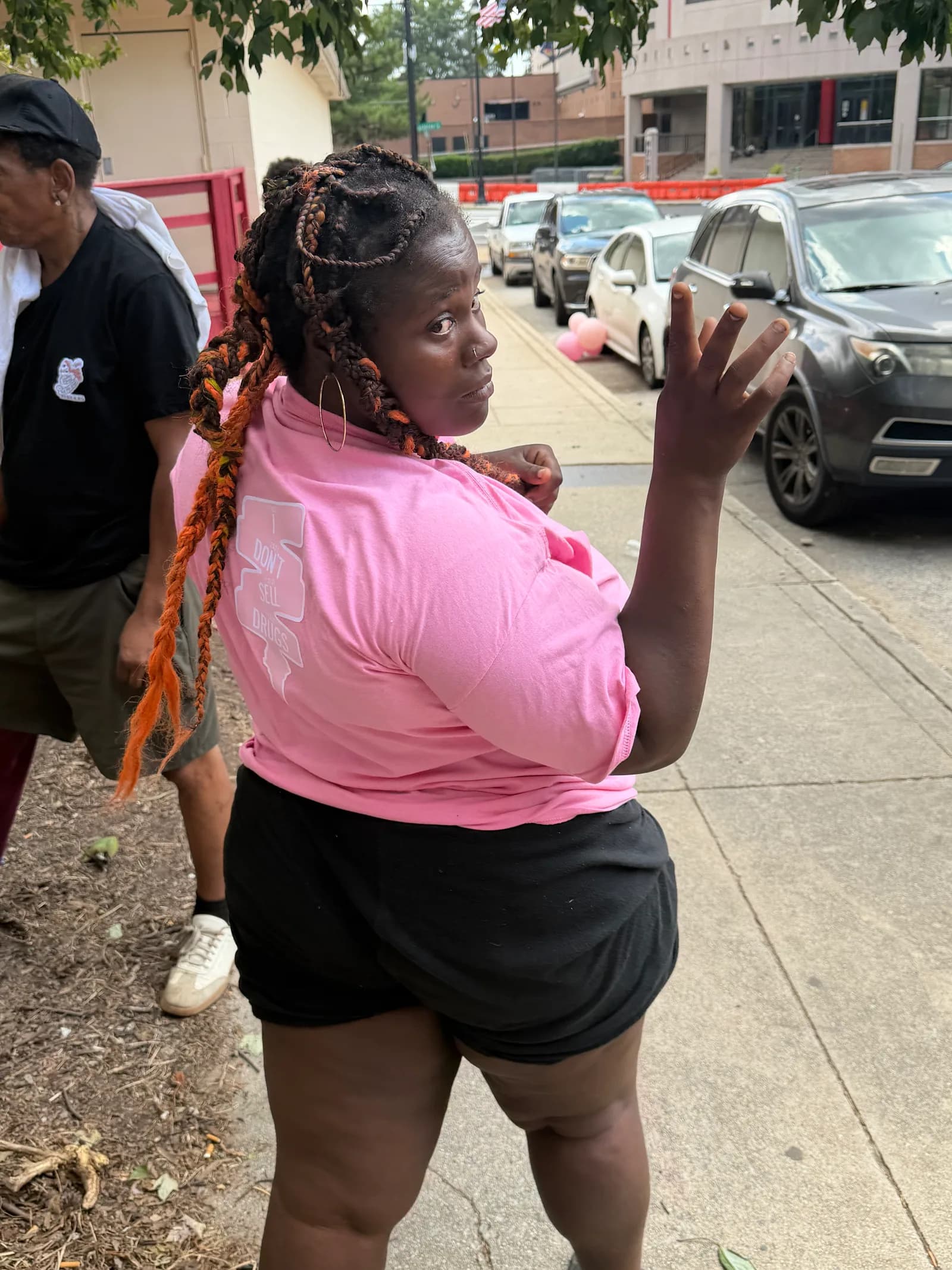 Woman wearing an XIISEEDS shirt smiling near a van