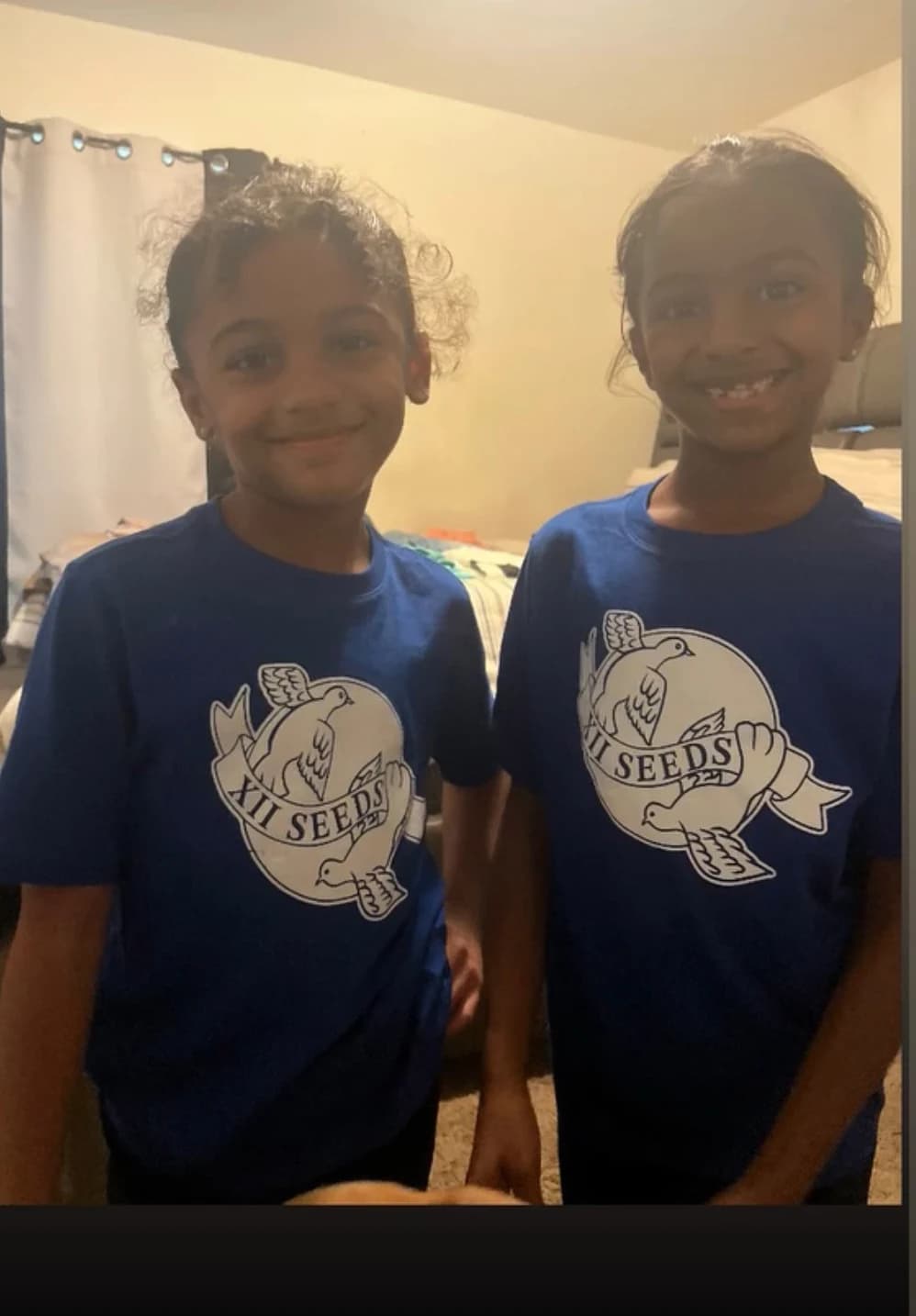 Two kids smiling in matching navy XII SEEDS dove tees