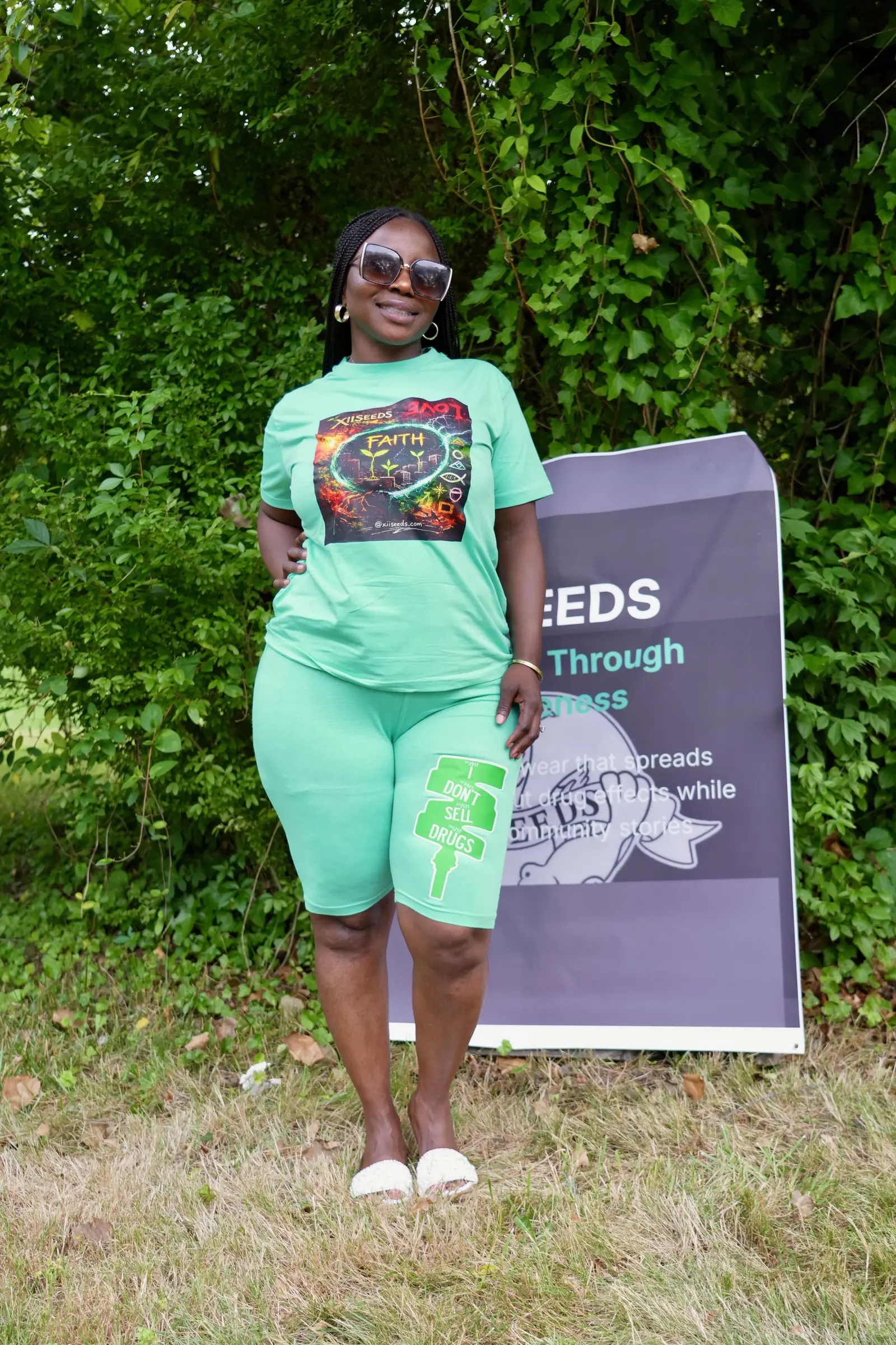 Woman in mint XII SEEDS FAITH set standing in front of the XIISEEDS banner