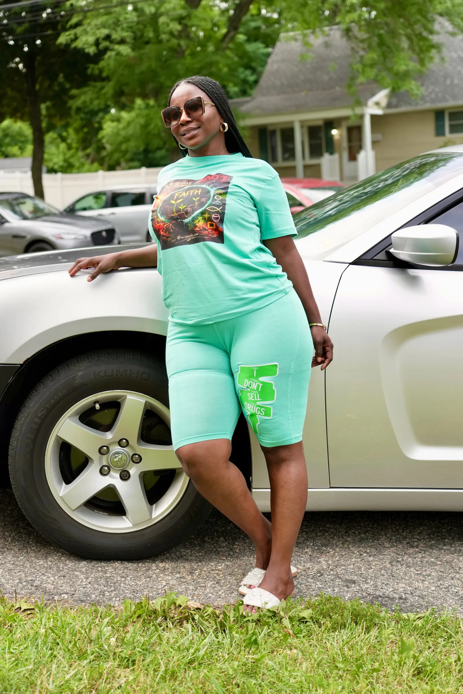 Woman in mint XII SEEDS FAITH set leaning against a car