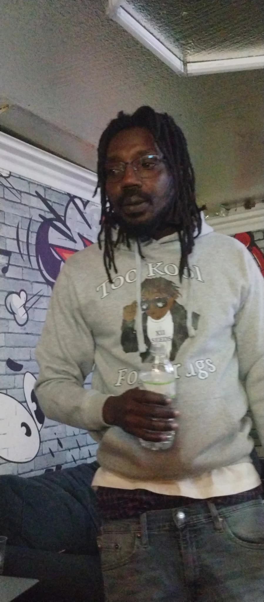 Peeterson wearing a gray 'Too Kool For Drugs' hoodie at a community event space