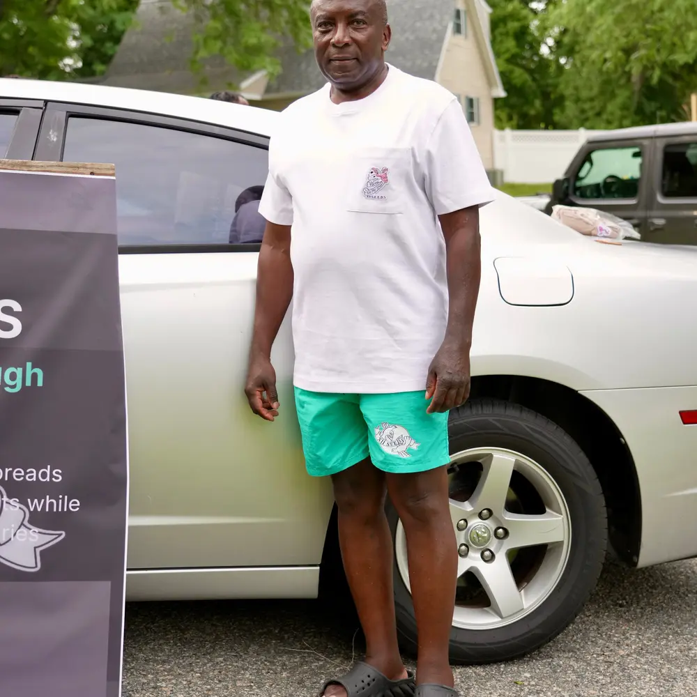 Man wearing a white XII SEEDS pocket tee and teal shorts set outdoors