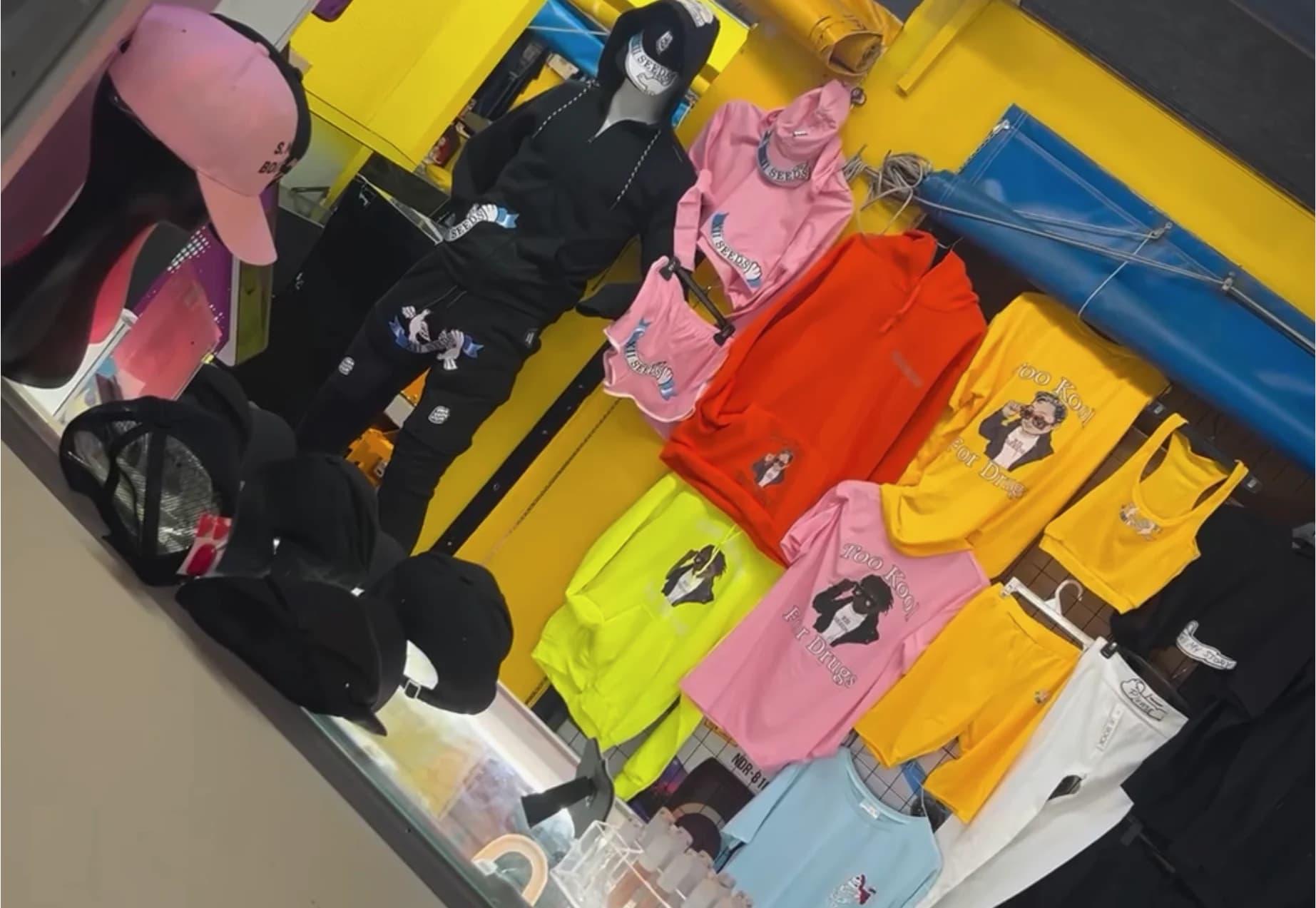 XII SEEDS store display wall with hoodies, tees, and caps in assorted colors