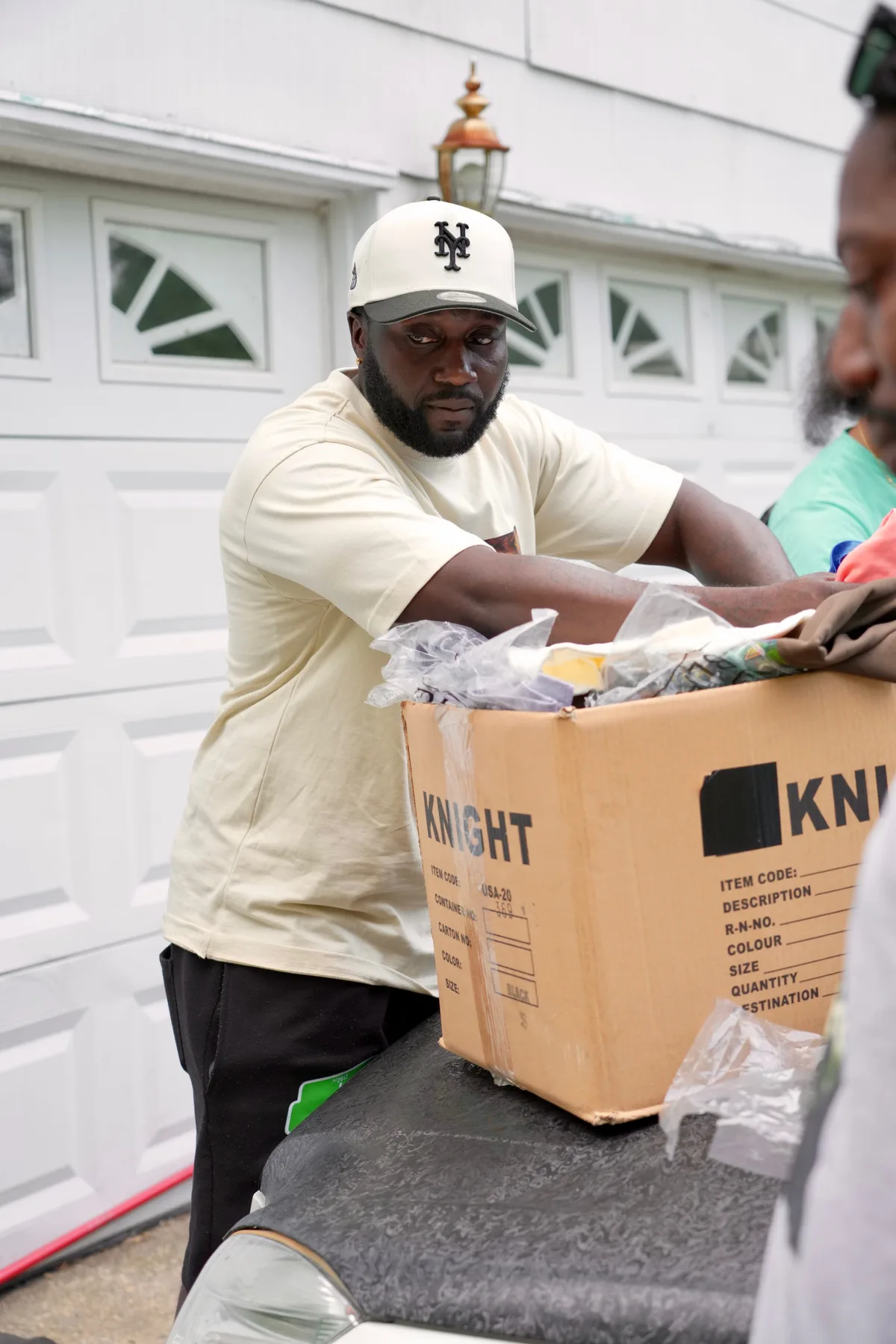 Man unpacking a box of XII SEEDS mission apparel