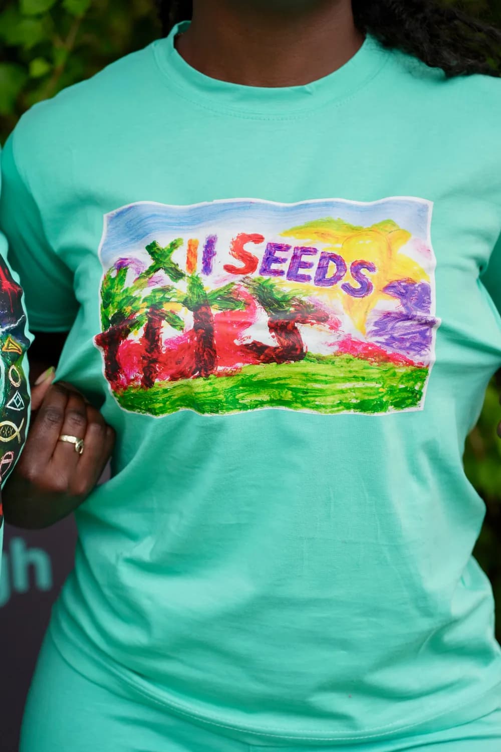 Woman wearing the hand-painted XII SEEDS palm tree graphic tee